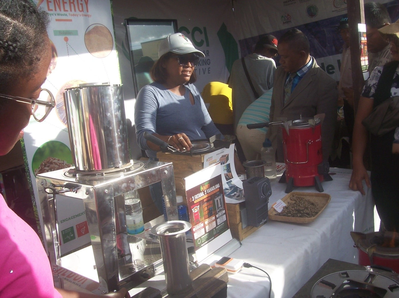 Les visiteurs sont intéressés par les cuisinières « cuisson propre » exposées au stand de BioGasikara Energy à la foire Fier-Mada